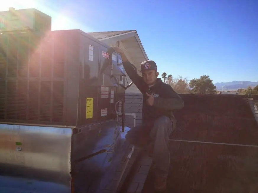 HVAC technician performing Heat Pump Repair on a rooftop unit in Blacksburg