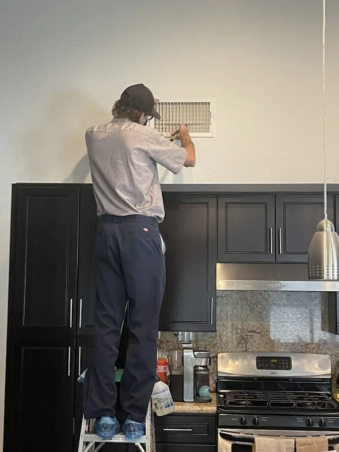 Technician inspecting an air vent during HVAC service in Blacksburg